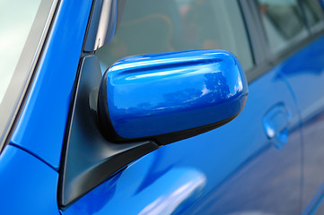 Image showing Right side mirror of shiny blue car