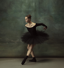 Image showing Young graceful tender ballerina on dark studio background