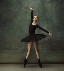 Image showing Young graceful tender ballerina on dark studio background