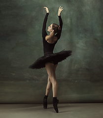 Image showing Young graceful tender ballerina on dark studio background