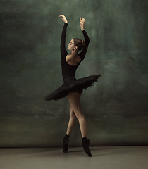 Image showing Young graceful tender ballerina on dark studio background