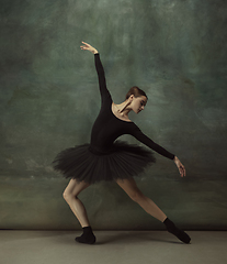 Image showing Young graceful tender ballerina on dark studio background