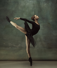 Image showing Young graceful tender ballerina on dark studio background