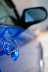 Image showing Right side mirror of shiny blue car