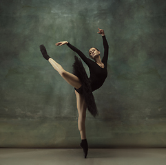 Image showing Young graceful tender ballerina on dark studio background