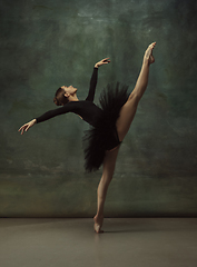 Image showing Young graceful tender ballerina on dark studio background