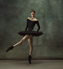 Image showing Young graceful tender ballerina on dark studio background