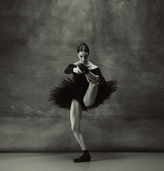 Image showing Young graceful tender ballerina on dark studio background