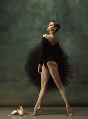 Image showing Young graceful tender ballerina on dark studio background