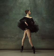 Image showing Young graceful tender ballerina on dark studio background