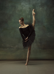 Image showing Young graceful tender ballerina on dark studio background
