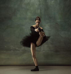 Image showing Young graceful tender ballerina on dark studio background