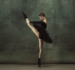 Image showing Young graceful tender ballerina on dark studio background