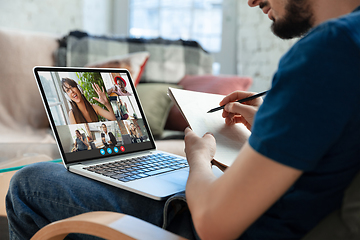 Image showing Man participate video conference looking at laptop screen during virtual meeting, videocall webcam app for business, close up