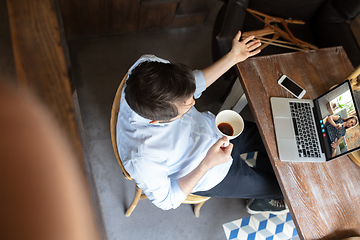 Image showing Man participate video conference looking at laptop screen during virtual meeting, videocall webcam app for business, close up