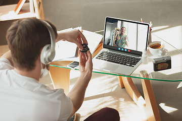 Image showing Man participate video conference looking at laptop screen during virtual meeting, videocall webcam app for business, close up