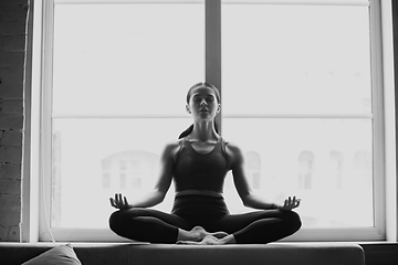 Image showing Sporty young woman practicing yoga at home