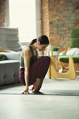 Image showing Sporty young woman practicing yoga at home