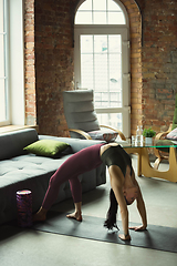 Image showing Sporty young woman practicing yoga at home