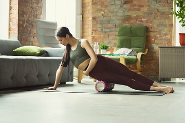 Image showing Sporty young woman practicing yoga at home