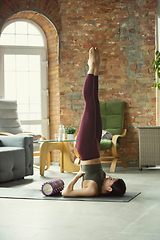 Image showing Sporty young woman practicing yoga at home