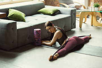 Image showing Sporty young woman practicing yoga at home