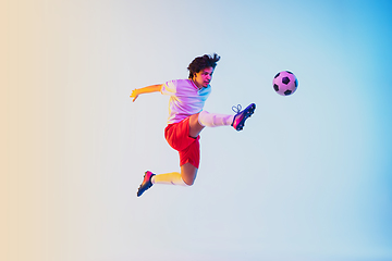 Image showing Football or soccer player on gradient background in neon light - motion, action, activity concept