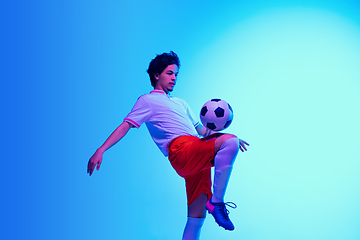 Image showing Football or soccer player on gradient background in neon light - motion, action, activity concept
