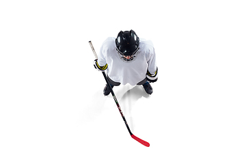 Image showing Unrecognizable male hockey player with the stick on ice court and white background