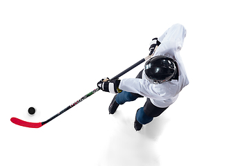 Image showing Unrecognizable male hockey player with the stick on ice court and white background