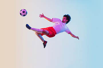 Image showing Football or soccer player on gradient background in neon light - motion, action, activity concept