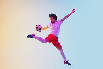 Image showing Football or soccer player on gradient background in neon light - motion, action, activity concept