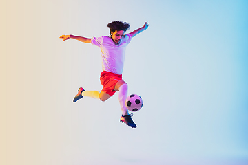 Image showing Football or soccer player on gradient background in neon light - motion, action, activity concept