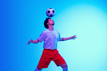 Image showing Football or soccer player on gradient background in neon light - motion, action, activity concept