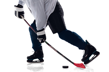 Image showing Unrecognizable male hockey player with the stick on ice court and white background