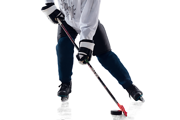 Image showing Unrecognizable male hockey player with the stick on ice court and white background