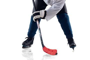 Image showing Unrecognizable male hockey player with the stick on ice court and white background