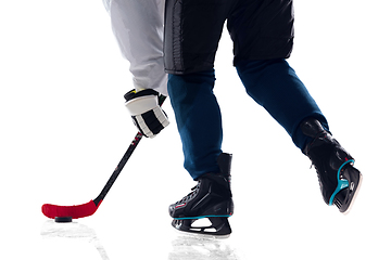 Image showing Unrecognizable male hockey player with the stick on ice court and white background