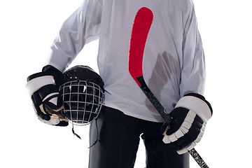 Image showing Unrecognizable male hockey player with the stick on ice court and white background