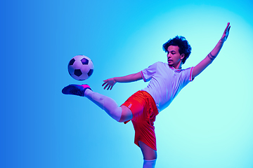 Image showing Football or soccer player on gradient background in neon light - motion, action, activity concept