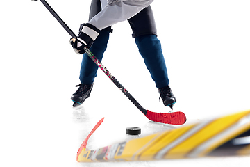 Image showing Unrecognizable male hockey player with the stick on ice court and white background