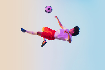 Image showing Football or soccer player on gradient background in neon light - motion, action, activity concept