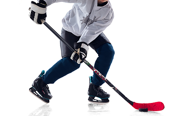 Image showing Unrecognizable male hockey player with the stick on ice court and white background