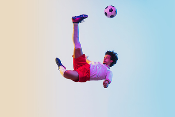 Image showing Football or soccer player on gradient background in neon light - motion, action, activity concept