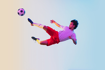 Image showing Football or soccer player on gradient background in neon light - motion, action, activity concept