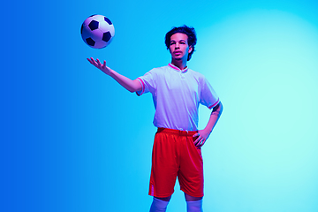 Image showing Football or soccer player on gradient background in neon light - motion, action, activity concept