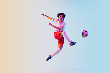 Image showing Football or soccer player on gradient background in neon light - motion, action, activity concept