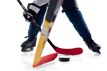 Image showing Unrecognizable male hockey player with the stick on ice court and white background