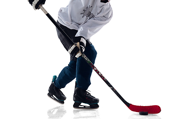 Image showing Unrecognizable male hockey player with the stick on ice court and white background