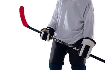 Image showing Unrecognizable male hockey player with the stick on ice court and white background